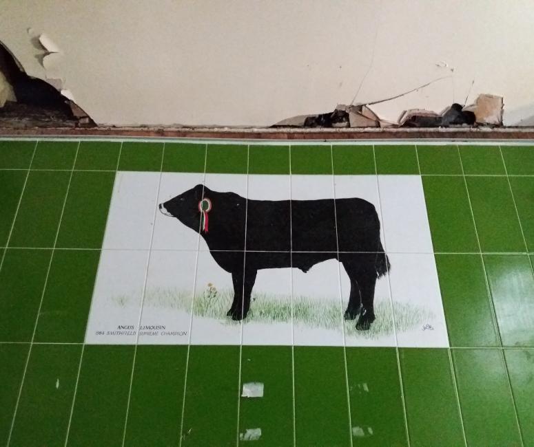An image of a black cow painted on tiles, found in the covered market