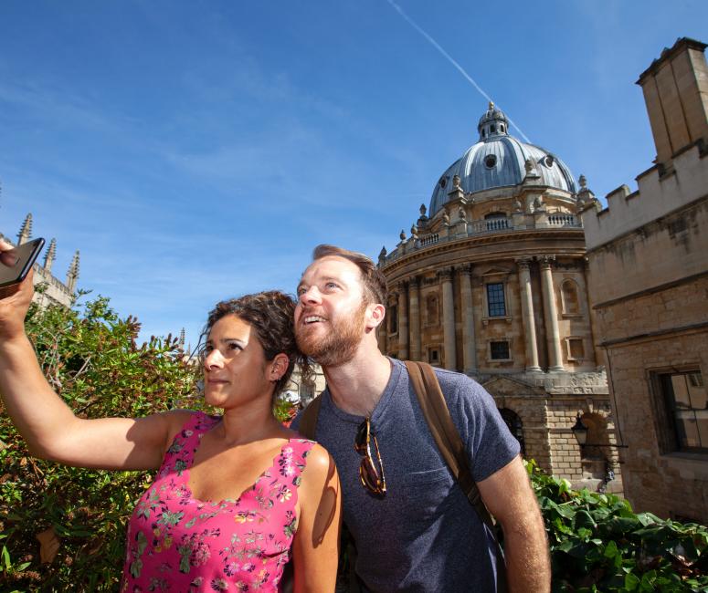 two people taking a picture with the radcliffe camera